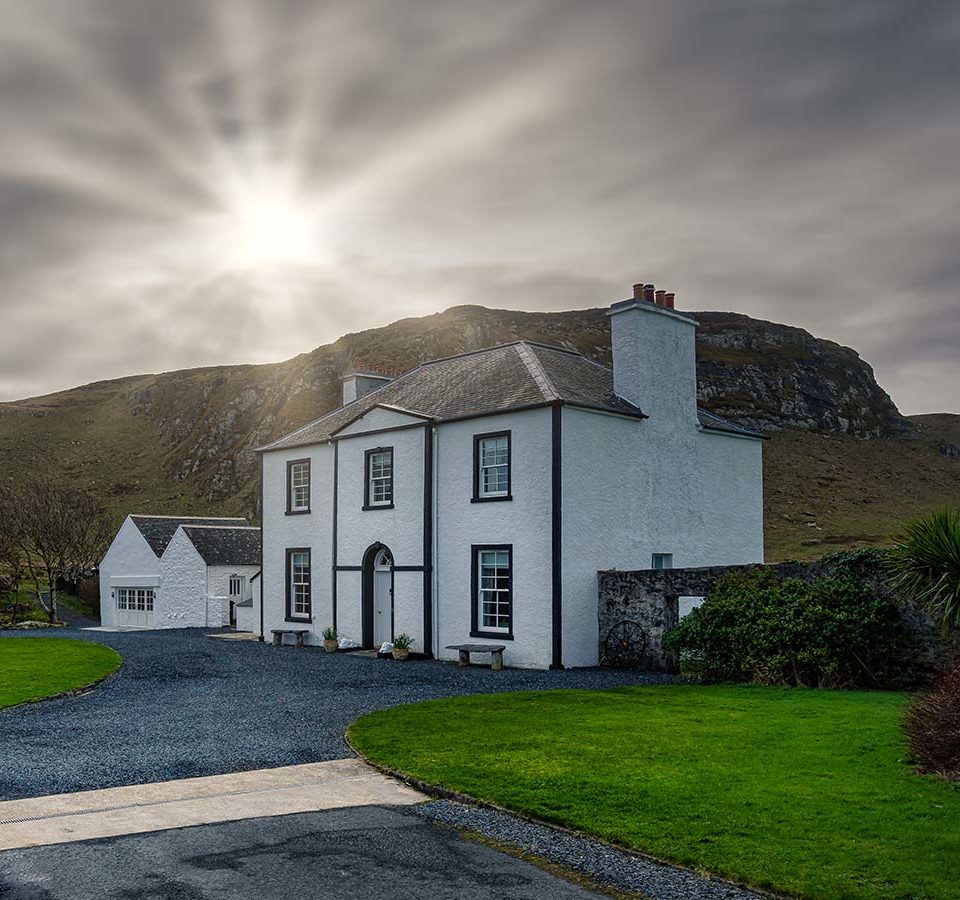 Kilchoman House with the sun behind it at Islay Cottages