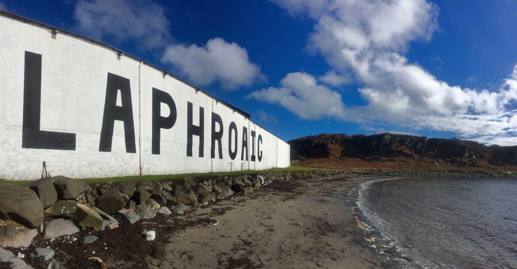 The exterior of Laphroaig Whisky Distillery running along the sealine