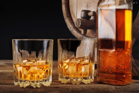 Two whisky glasses, a bottle of whisky and a whisky barrel