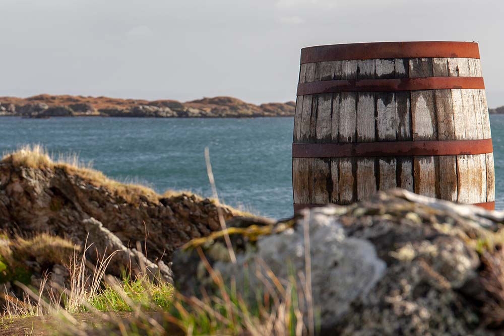 A whisky barrel by water on Islay.